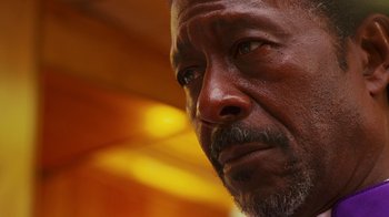 Movie still from “Red Hook Summer” (2012), directed by Spike Lee – A man's face in a room with yellow lighting; Close Up shot, Low angle