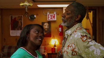 Movie still from “Red Hook Summer” (2012), directed by Spike Lee – A man and a woman standing next to each other in a room; Medium shot, Over the shoulder angle