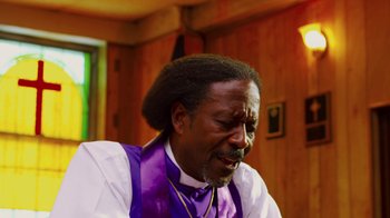 Movie still from “Red Hook Summer” (2012), directed by Spike Lee – A man in a purple vest and white shirt; Close Up shot, Low angle