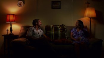 Movie still from “Red Hook Summer” (2012), directed by Spike Lee – A man and a woman sitting on a couch talking; Medium shot, High angle