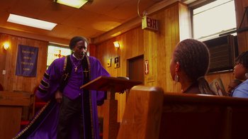 Movie still from “Red Hook Summer” (2012), directed by Spike Lee – A man in a purple robe is speaking to a woman; Medium shot, Low angle