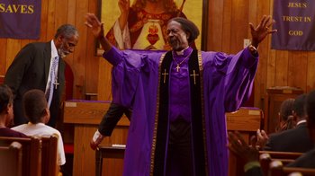 Movie still from “Red Hook Summer” (2012), directed by Spike Lee – A man in a purple robe and a cross on his chest; Medium shot, Low angle