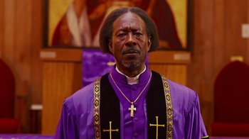 Movie still from “Red Hook Summer” (2012), directed by Spike Lee – A man in a purple robe and a cross on his chest; Close Up shot, Low angle
