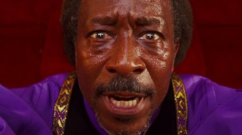Movie still from “Red Hook Summer” (2012), directed by Spike Lee – An older man with brown hair and a purple shirt is crying; Extreme Close Up shot, Low angle