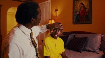 Movie still from “Red Hook Summer” (2012), directed by Spike Lee – A young boy getting his head examined by a doctor; Medium shot, Over the shoulder angle