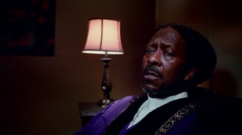 Movie still from “Red Hook Summer” (2012), directed by Spike Lee – A man in a purple robe sitting in front of a lamp; Close Up shot, Low angle