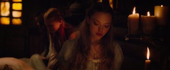 Movie still from “Red Riding Hood” (2011), directed by Catherine Hardwicke – A young woman with long blonde hair sitting next to another young man; Close Up shot, High angle