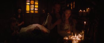 Movie still from “Red Riding Hood” (2011), directed by Catherine Hardwicke – Two women lighting candles in a dark room; Medium shot, Over the shoulder angle