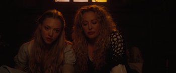 Movie still from “Red Riding Hood” (2011), directed by Catherine Hardwicke – Two women sitting next to each other in a dark room; Close Up shot, High angle