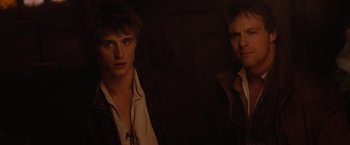 Movie still from “Red Riding Hood” (2011), directed by Catherine Hardwicke – Two men standing next to each other in a dark room; Close Up shot, Over the shoulder angle