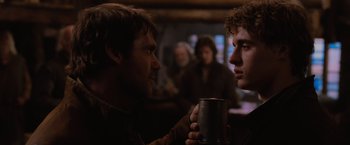 Movie still from “Red Riding Hood” (2011), directed by Catherine Hardwicke – Two people are holding a mug in a bar; Close Up shot, Over the shoulder angle