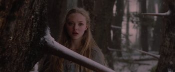 Movie still from “Red Riding Hood” (2011), directed by Catherine Hardwicke – A woman standing next to a rail in the woods; Close Up shot, Over the shoulder angle