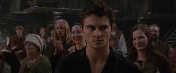 Movie still from “Red Riding Hood” (2011), directed by Catherine Hardwicke – A man standing in front of a group of people; Close Up shot, Over the shoulder angle