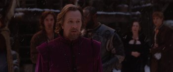 Movie still from “Red Riding Hood” (2011), directed by Catherine Hardwicke – A man with a long beard wearing a purple jacket; Medium shot, Over the shoulder angle