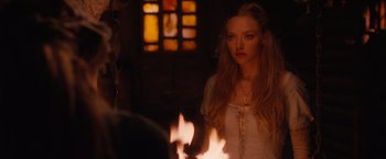 Movie still from “Red Riding Hood” (2011), directed by Catherine Hardwicke – A beautiful young woman standing in front of fire; Close Up shot, Over the shoulder angle