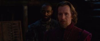 Movie still from “Red Riding Hood” (2011), directed by Catherine Hardwicke – A man standing next to another man in a dark room; Close Up shot, Over the shoulder angle