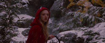 Movie still from “Red Riding Hood” (2011), directed by Catherine Hardwicke – A woman in a red coat holding a cane in the snow; Medium shot, High angle