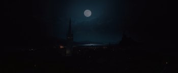 Movie still from “Red Riding Hood” (2011), directed by Catherine Hardwicke – A full moon rises in the night sky over a city; Extreme Wide shot, High angle