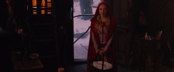 Movie still from “Red Riding Hood” (2011), directed by Catherine Hardwicke – A woman in a red hooded cape holding a basket; Wide shot, High angle