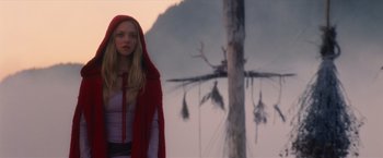 Movie still from “Red Riding Hood” (2011), directed by Catherine Hardwicke – A woman wearing a red hooded cape standing in front of a tree; Medium shot, Low angle