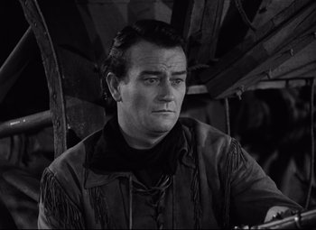 Movie still from “Red River” (1948), directed by Howard Hawks – A black and white photo of a man in a leather jacket; Medium shot, Low angle