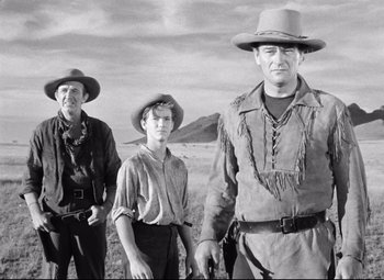 Movie still from “Red River” (1948), directed by Howard Hawks – A group of men standing next to each other in a field; Medium shot, Low angle