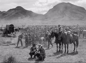 Movie still from “Red River” (1948), directed by Howard Hawks – A black and white photo of men on horses in a field; Extreme Wide shot, Over the shoulder angle