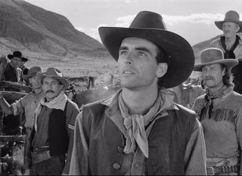 Movie still from “Red River” (1948), directed by Howard Hawks – A group of men standing next to each other in a field; Medium shot, Low angle