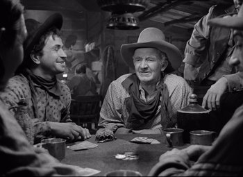 Movie still from “Red River” (1948), directed by Howard Hawks – A group of men sitting at a table playing cards; Medium shot, Over the shoulder angle