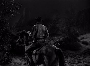 Movie still from “Red River” (1948), directed by Howard Hawks – A man riding on the back of a brown horse; Wide shot, Low angle