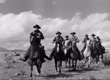Movie still from “Red River” (1948), directed by Howard Hawks – A black and white photo of men on horses; Wide shot, Low angle