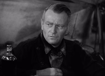 Movie still from “Red River” (1948), directed by Howard Hawks – An older man is looking at the camera while wearing a jacket; Close Up shot, Over the shoulder angle