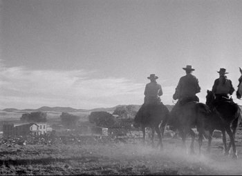 Movie still from “Red River” (1948), directed by Howard Hawks – Two men on horseback riding across a dry grass field; Extreme Wide shot, Low angle