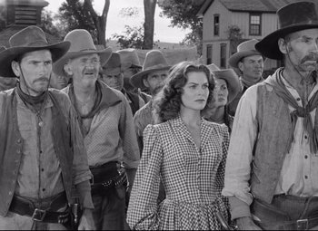 Movie still from “Red River” (1948), directed by Howard Hawks – A group of men and women standing next to each other; Medium shot, Low angle