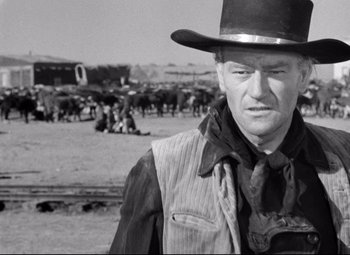 Movie still from “Red River” (1948), directed by Howard Hawks – A black and white photo of a man wearing a cowboy hat; Medium shot, Over the shoulder angle