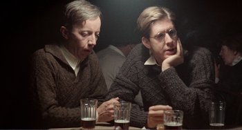 Movie still from “Reds” (1981), directed by Warren Beatty – A couple of men sitting next to each other at a table; Close Up shot, Over the shoulder angle