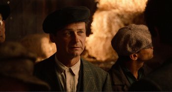 Movie still from “Reds” (1981), directed by Warren Beatty – A person wearing a suit and a hat; Close Up shot, Over the shoulder angle