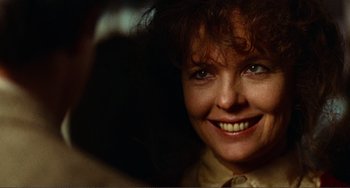 Movie still from “Reds” (1981), directed by Warren Beatty – A woman smiling for the camera; Close Up shot, Over the shoulder angle