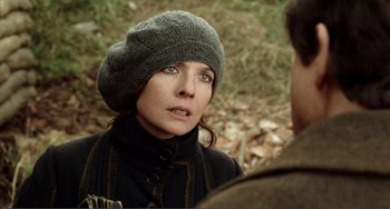 Movie still from “Reds” (1981), directed by Warren Beatty – A woman wearing a gray hat and a black jacket; Close Up shot, Over the shoulder angle
