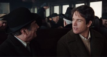 Movie still from “Reds” (1981), directed by Warren Beatty – Two men are talking in a train car; Medium shot, Over the shoulder angle