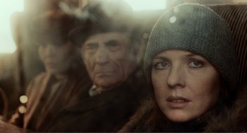 A man and a woman are looking out of a window
