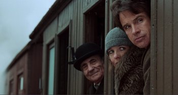 Movie still from “Reds” (1981), directed by Warren Beatty – A group of people standing next to each other in front of a building; Medium shot, Low angle