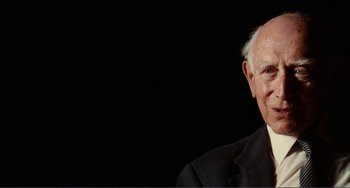 Movie still from “Reds” (1981), directed by Warren Beatty – An older man wearing a suit is smiling; Close Up shot, Low angle