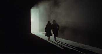 Movie still from “Reds” (1981), directed by Warren Beatty – Two people are walking down the street in the dark; Wide shot, Low angle