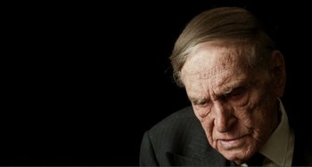 Movie still from “Reds” (1981), directed by Warren Beatty – An older man in a suit is looking down; Close Up shot, Over the shoulder angle