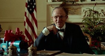 Movie still from “Reds” (1981), directed by Warren Beatty – An older man sitting in front of an american flag; Close Up shot, Low angle