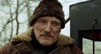 Movie still from “Reds” (1981), directed by Warren Beatty – A person wearing a jacket and a hat; Close Up shot, Low angle