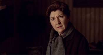 Movie still from “Reds” (1981), directed by Warren Beatty – An older woman wearing a sweater and a scarf; Close Up shot, Low angle