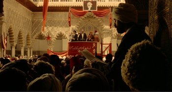 Movie still from “Reds” (1981), directed by Warren Beatty – A group of people standing in front of an audience; Extreme Wide shot, High angle