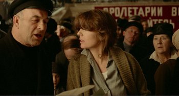 Movie still from “Reds” (1981), directed by Warren Beatty – A woman in a crowd of people; Medium shot, Over the shoulder angle